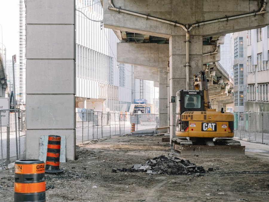 Channelizing barrel and heavy equipment working beneath an elevated highway structure